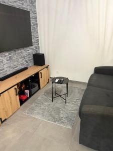 a living room with a couch and a flat screen tv at Grand Studio Neuf in Ajaccio