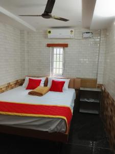 a bedroom with a large bed with red pillows at Shanmikha Residency - Attur - Near Highways in Āttūr