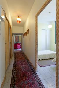 a hallway with a room with a bed and a rug at My Beaucaire in Beaucaire