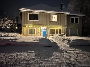 a house with a blue door in the snow at Alaska Tucked Inn in Fairbanks