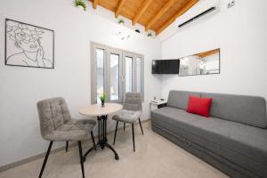 a living room with a couch and a table and chairs at Oniro Living - Skra 10 in Mytilene
