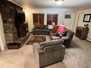 a living room with two couches and a stone fireplace at Alaska Tucked Inn in Fairbanks