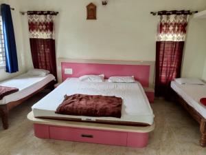 a bedroom with two beds with red curtains at HALASE HOMESTAY mudigere in Mudigere