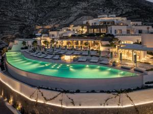 an aerial view of a hotel with a pool at night at Sandblu Santorini, LXR Hotels & Resorts in Kamari