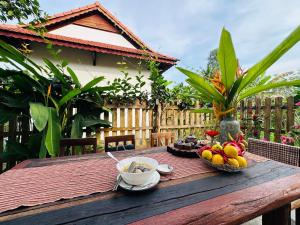 a wooden table with bowls of fruit on it at Rustic Homeaway - Stay with the local in Phong Ðiền