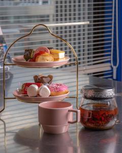 a table with two plates of donuts and a cup of tea at THE BASEMENT HOTEL OsakaHonmachi in Osaka