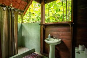 a bathroom with a sink and a shower at Dolphin Quest Jungle Lodge in Piedras Blancas +104 photos