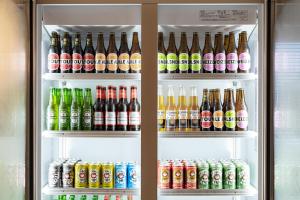 a refrigerator filled with lots of drinks and sodas at THE BASEMENT HOTEL OsakaHonmachi in Osaka