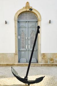 an umbrella in front of a building with a door at GuestMar in Olhão