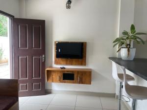 a living room with a tv on a wall at Poozhikuth Homestay in Sultan Bathery