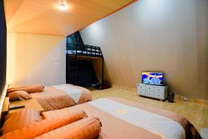 a bedroom with two beds and a bunk bed at Villa Kebon Paman in Balong