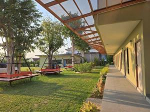 a group of swings in a yard next to a building at The Y Habitat in Kanchanaburi City