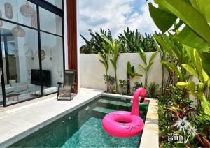 a pink swan in a swimming pool in a house at Surya Palm Villa in Tumbak Bayuh
