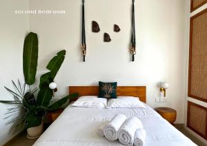 a bedroom with a white bed with towels on it at Surya Palm Villa in Tumbak Bayuh +10 photos