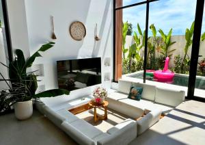 a living room with a white couch and a fireplace at Surya Palm Villa in Tumbak Bayuh