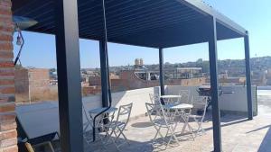 a patio with chairs and tables on a roof at AG Dusty Luxe Suite #3 in San Miguel de Allende