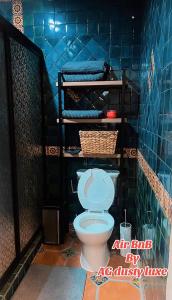 a bathroom with a toilet in a blue tiled room at AG Dusty Luxe Suite #3 in San Miguel de Allende