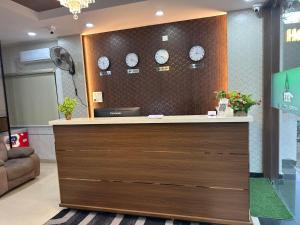 a lobby with a counter with clocks on the wall at Hotel Apex Inn Hyderabad Airport in Hyderabad