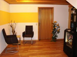 a living room with two chairs and a door at Gäste-Haus Rösch in Wiesent