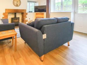 a blue couch in a living room with a fireplace at Colby Hall Cottage in Colby