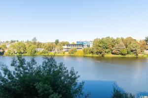 a view of a lake with trees and a building at Vista Premium Laguna Centro Concepción in Concepción