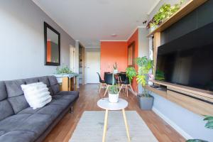 a living room with a couch and a flat screen tv at Vista Premium Laguna Centro Concepción in Concepción