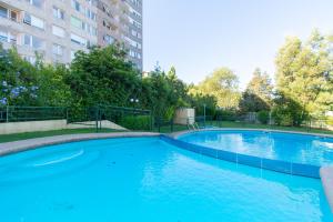 a large swimming pool in front of a building at Vista Premium Laguna Centro Concepción in Concepción