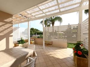 a patio with a white pergola and a table at Studio for couples in Capo Vaticano with pool in Capo Vaticano