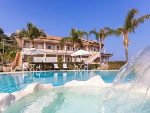 a swimming pool with a fountain in front of a house at Studio for couples in Capo Vaticano with pool in Capo Vaticano