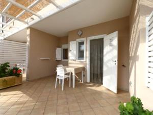 a patio with a table and chairs and a window at Studio for couples in Capo Vaticano with pool in Capo Vaticano