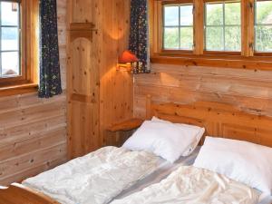 two beds in a room with wooden walls and windows at 4 person holiday home in olden in Olden