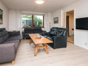 a living room with a couch and a coffee table at 4 star holiday home in Allingåbro in Allingåbro