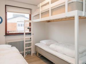 a bedroom with two bunk beds and a window at 4 star holiday home in Allingåbro in Allingåbro +32 photos