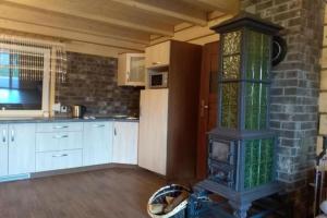 a kitchen with a stove in the middle of a room at Holiday homes with fireplaces, playground in Lubrza +30 photos