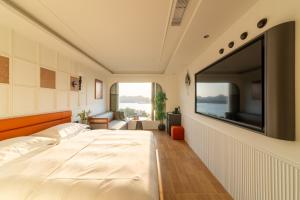 a bedroom with a large bed with a large flat screen tv at NiaoDao Seaview Hotel in Xiamen