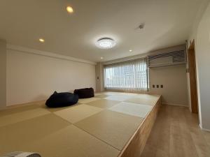 a large empty room with a large window and a couch at Guesthouse Matsu 別館 in Osaka