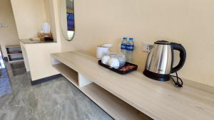 a counter with a coffee maker and water bottles at The Y Habitat in Kanchanaburi City