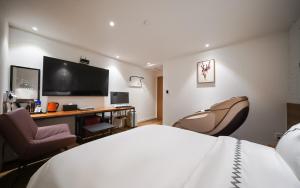 a hotel room with a bed and a desk and a tv at MARI hotel in Incheon