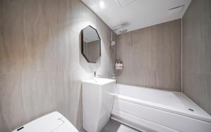 a bathroom with a toilet and a sink and a mirror at MARI hotel in Incheon