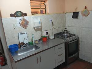 a small kitchen with a sink and a stove at Hostal Mechita Mamani in Cafayate