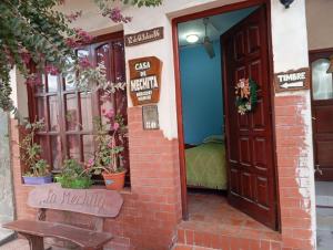 an entrance to a restaurant with a door and a bench at Hostal Mechita Mamani in Cafayate