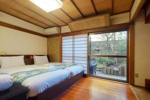 a bedroom with two beds and a large window at Yuririan in Kyoto