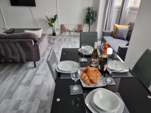 a living room with a table with plates and wine glasses at Away Home in London +2 photos