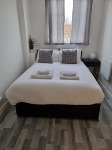 a bedroom with a large bed with two pillows at Away Home in London