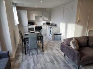 a living room with a couch and a table and a kitchen at Away Home in London