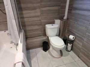 a bathroom with a white toilet and a shower at Away Home in London