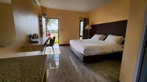 a bedroom with a bed and a desk in a room at The Y Habitat in Kanchanaburi City