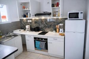 a kitchen with white appliances and a white refrigerator at T3 climatisé avec terrasse proche plages in Rivière-Pilote +9 photos
