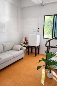 a living room with a couch and a piano at Lawans Hostel in Pattaya South