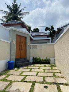 a house with a wooden door in front of it at Villa Bulan by MentariPro Bali in Singaraja